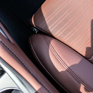 Perforated brown leather seat cover with contrast stitching