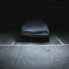Car protected with a fitted top cover in a dark garage