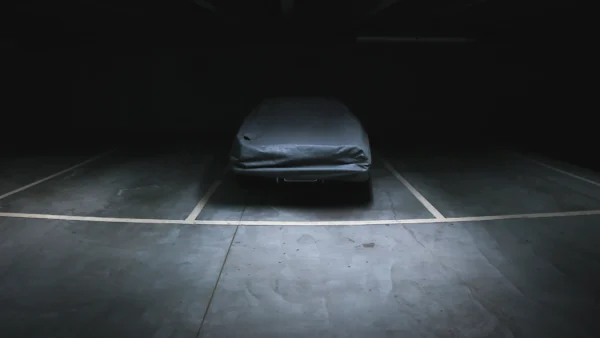 Car protected with a fitted top cover in a dark garage
