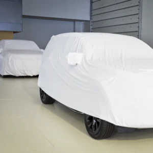 Cars protected with white indoor car top covers